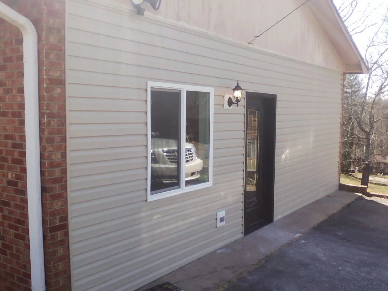 New vinyl siding and entry door on a room addition in Williamson