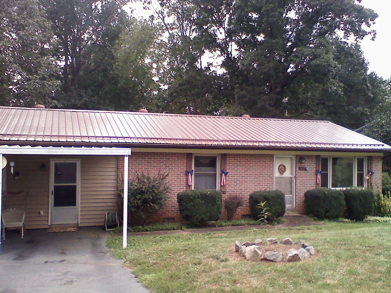 Bronze metal roof and carport on a brick ranch home — Roof Repair work by our crew in Williamson