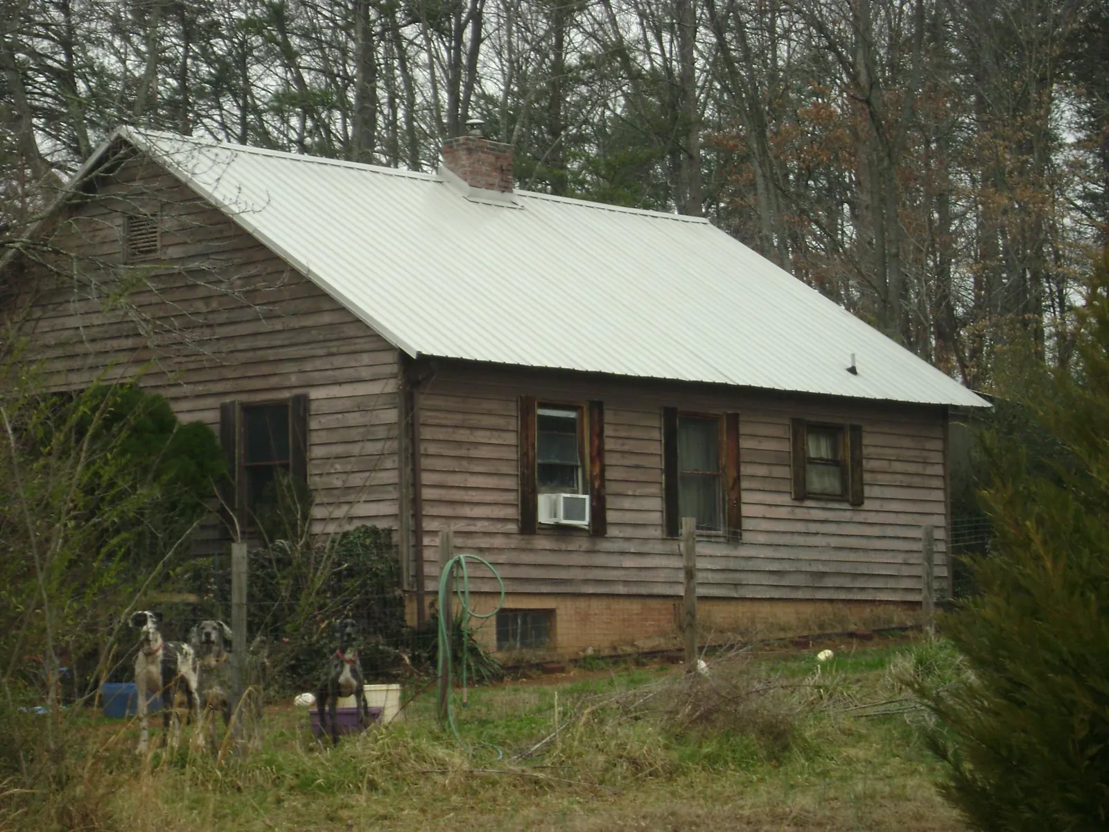 White metal roof on an old wood sided farmhouse, from a Metal Roof Installation job in Williamson